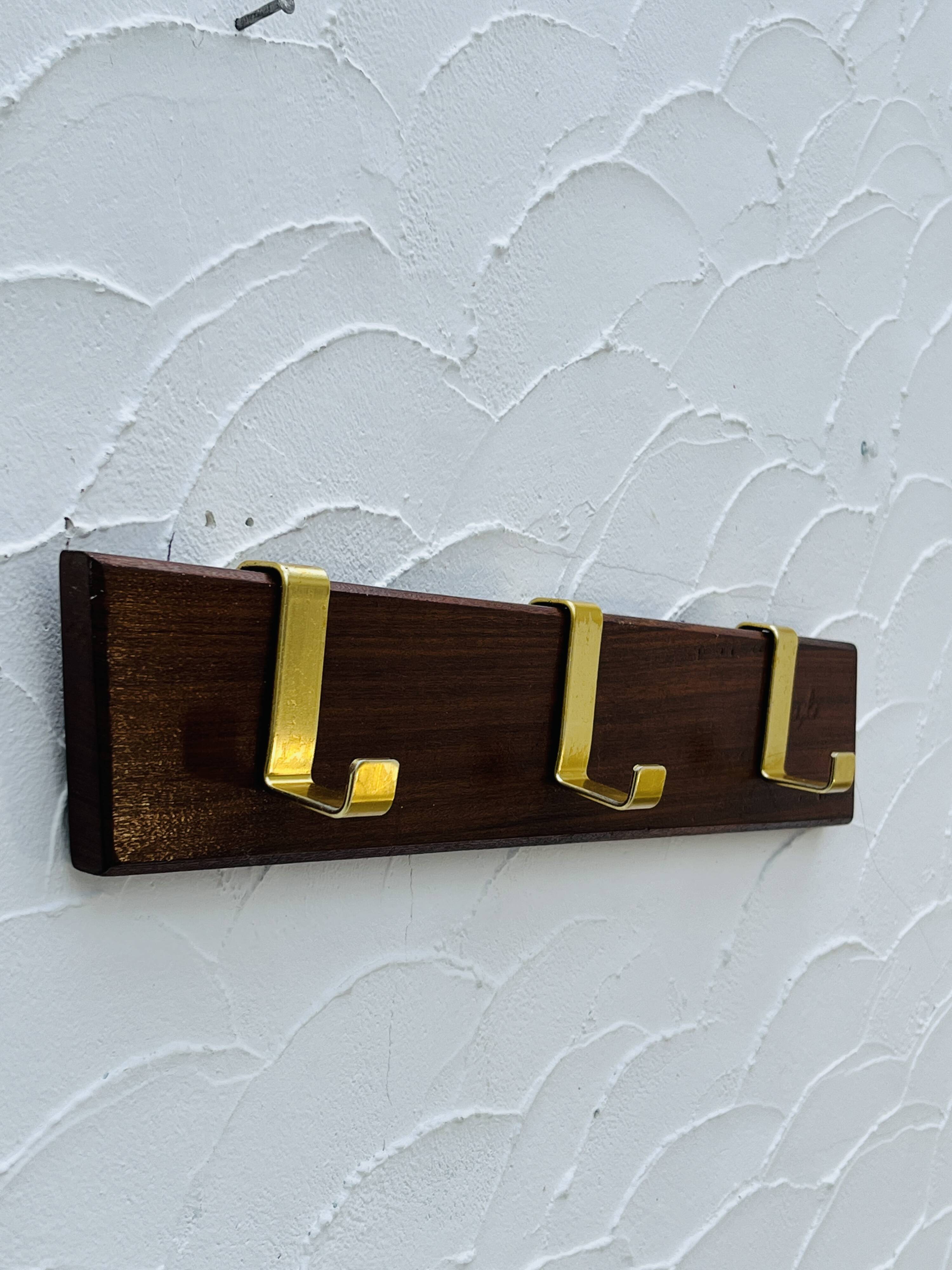 Vintage wooden and brass coat rack with 3 hooks from the 1960s.