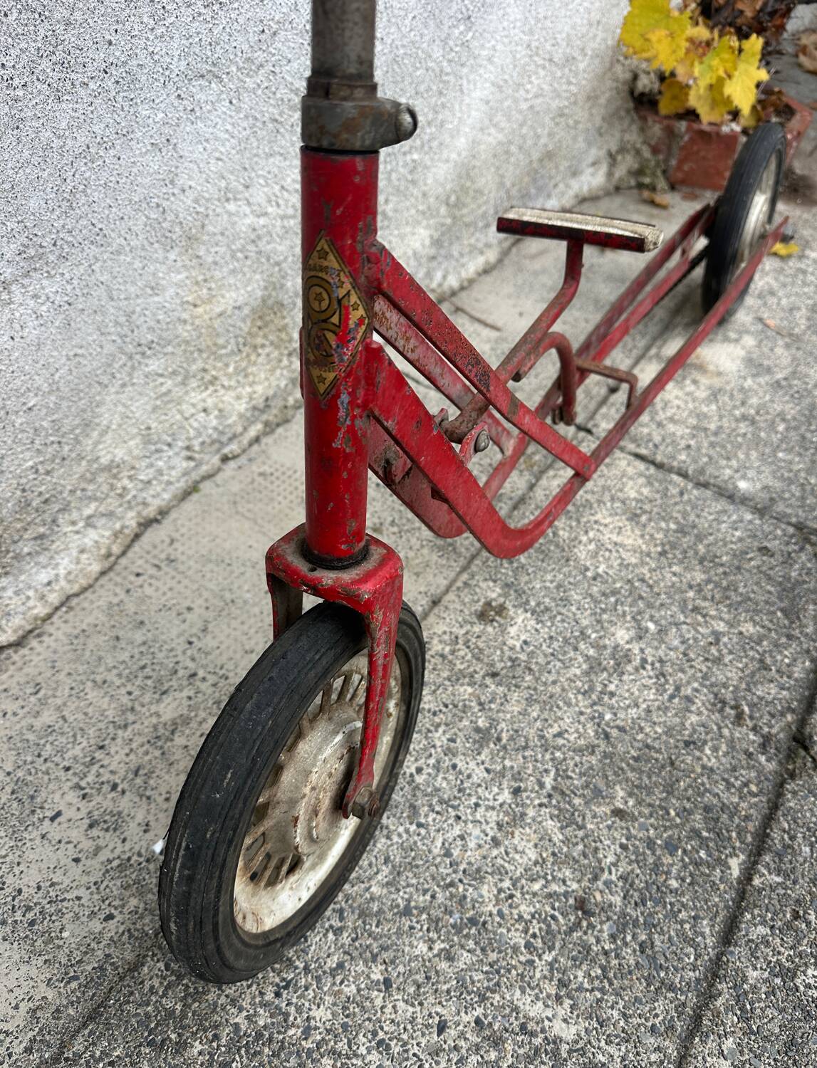 Trottinette rouge ancienne à pédale et chaîne