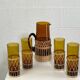 Vintage service for orangeade in amber glass and wicker.
