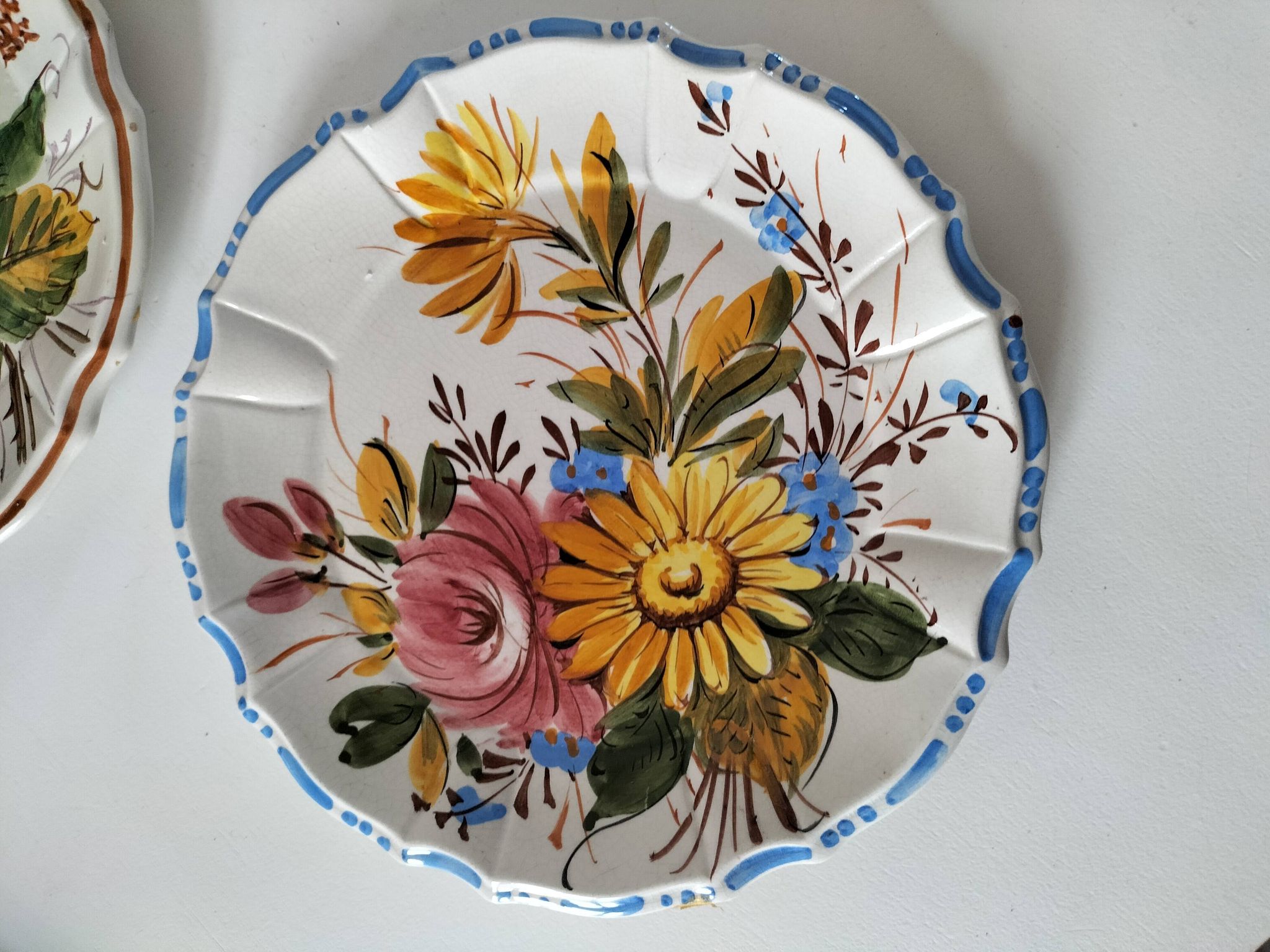 Set of three earthenware plates from Bassano, hand-painted with fruit and flower designs.