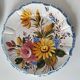 Set of three earthenware plates from Bassano, hand-painted with fruit and flower designs.