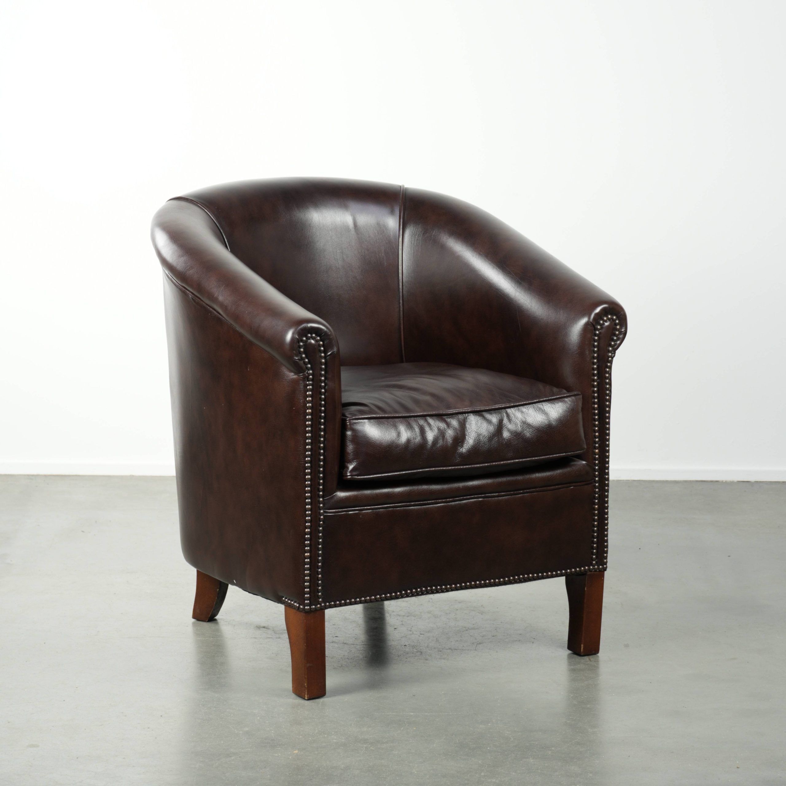 Dark cow leather club armchair in good condition with an English design
