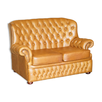 Small Chesterfield leather sofa with a high back.