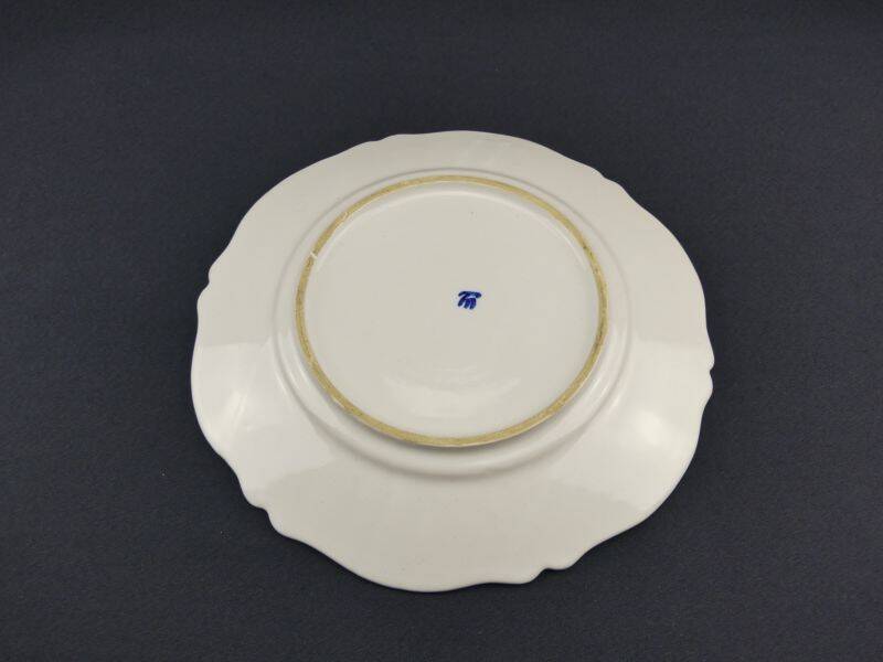 Old earthenware dish with a floral basket decoration.