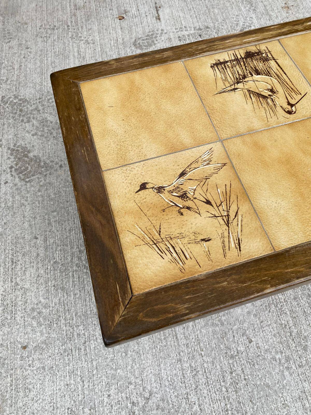 Vintage 70s coffee table with wood and ceramic tiles featuring bird and nature patterns.