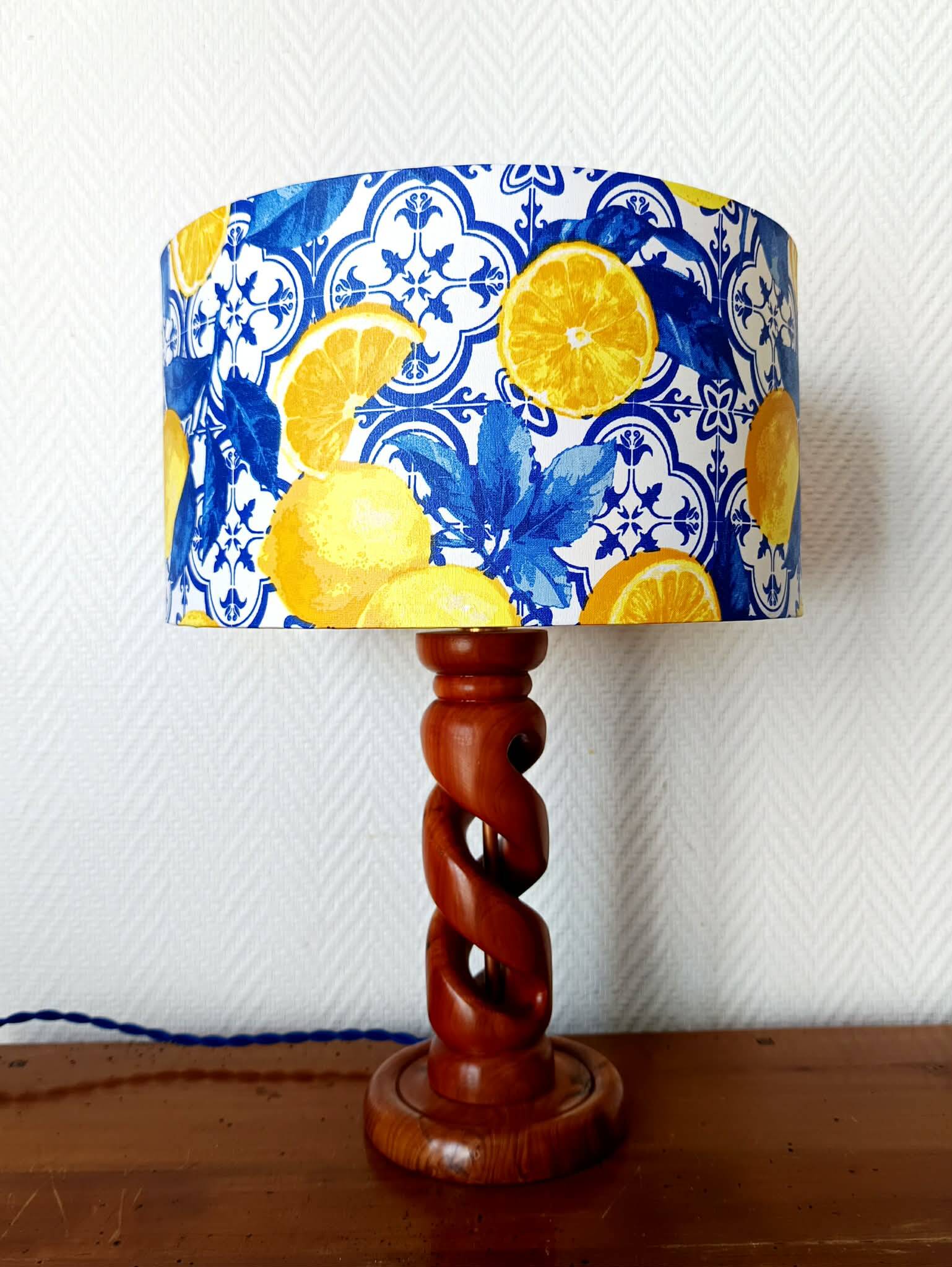 Turned wooden lamp with a lampshade featuring lemon tiles.