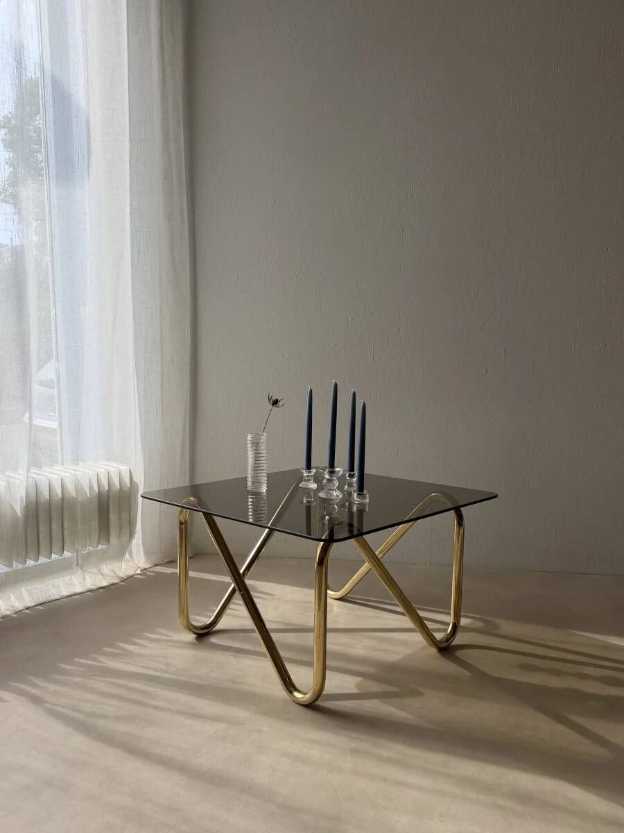 Coffee table with smoked glass and curved metal base