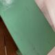 Vintage wooden footrest in mint green.
