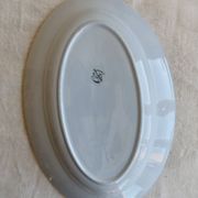 Antique oval serving dish in pale blue earthenware with a small flower design.