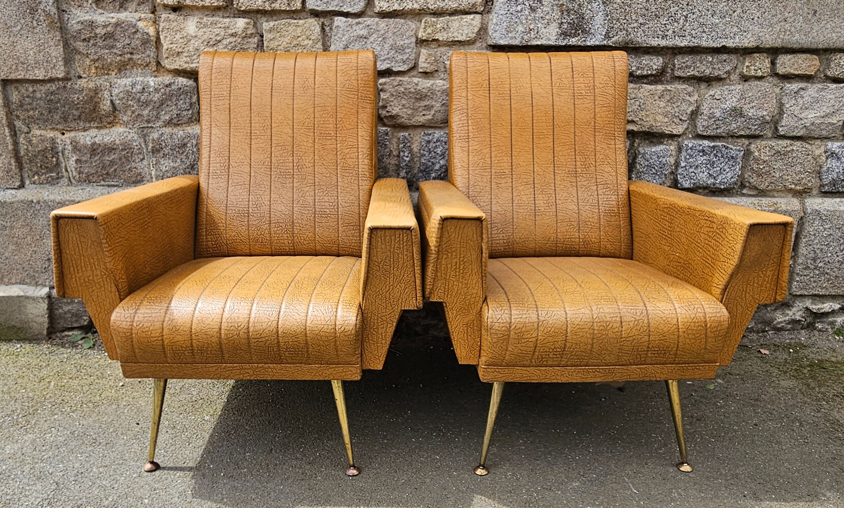 Pair of mustard skaï armchairs, brass feet