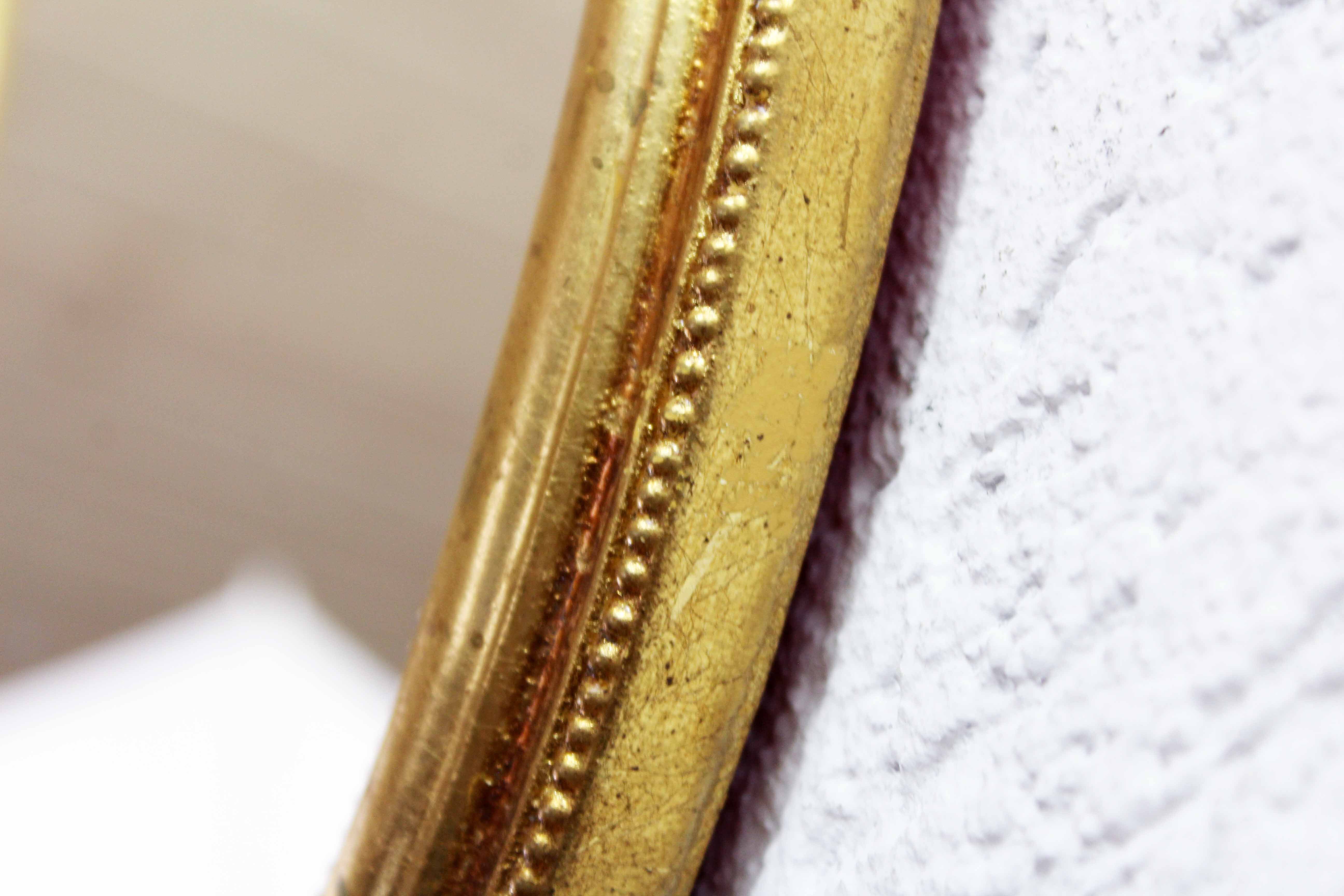 Golden oval mirror with leaf