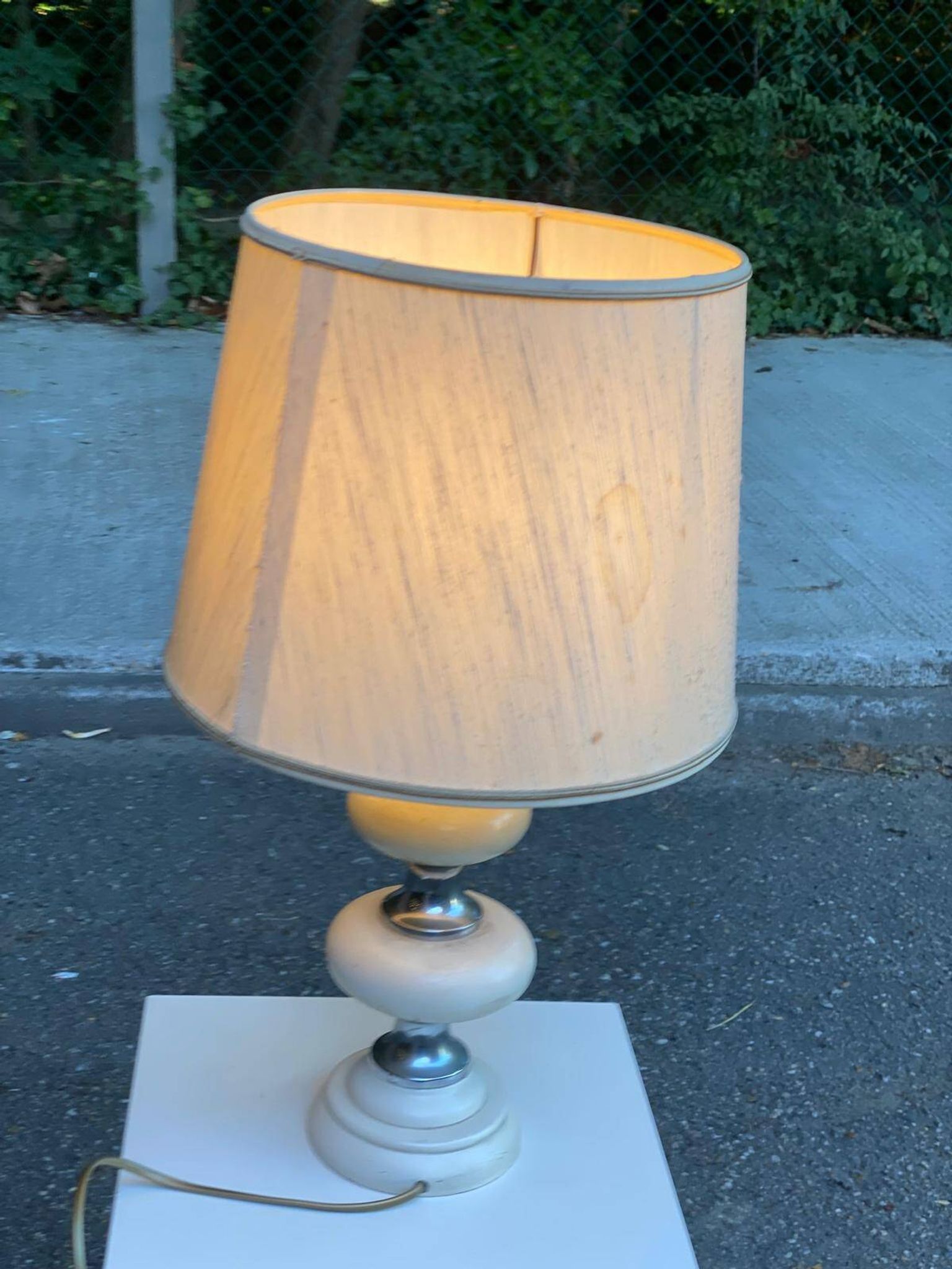Space age bedside lamp in off-white wood with a metal band.