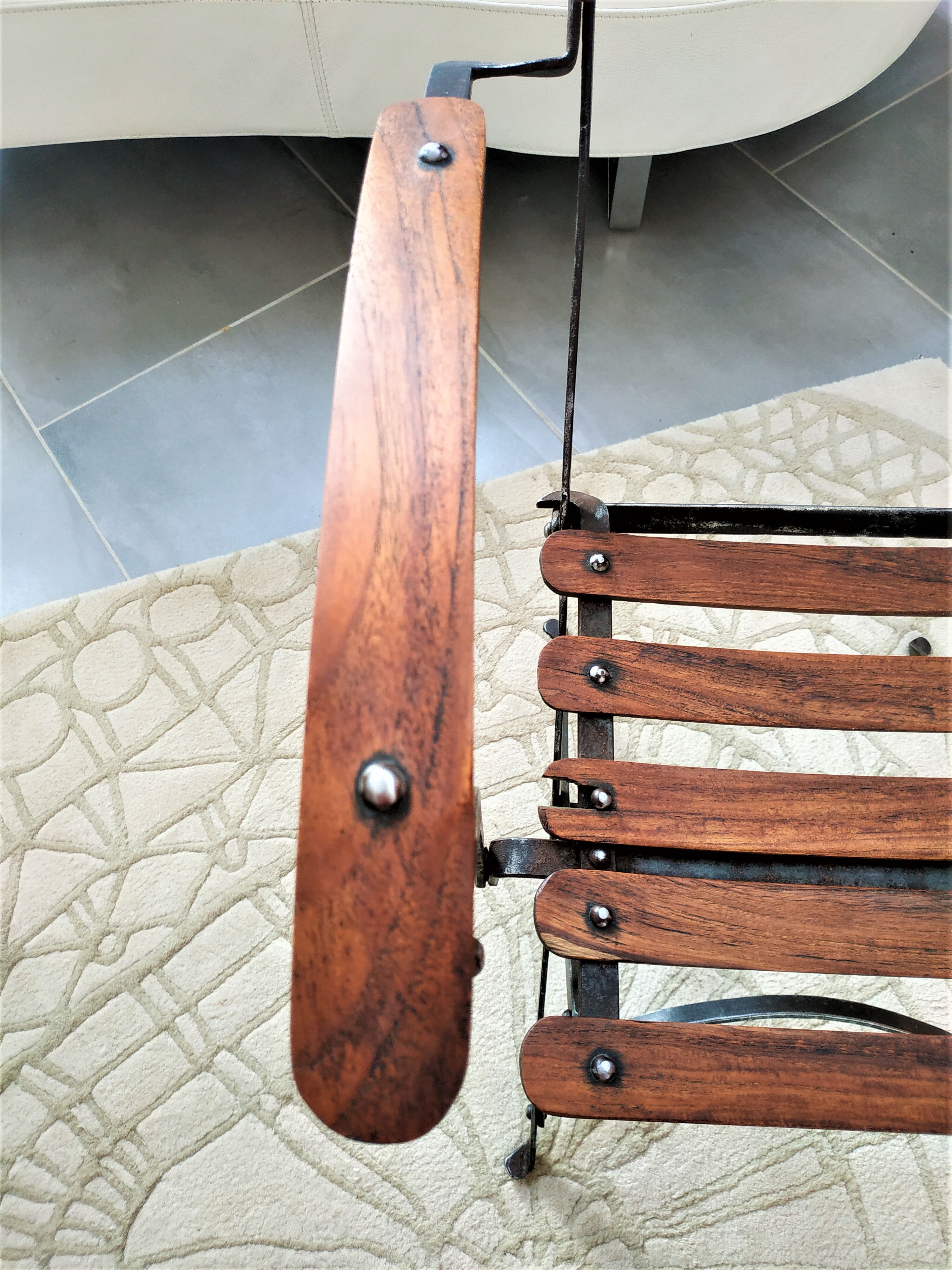 Folding garden chair with teak slats on a wrought iron structure