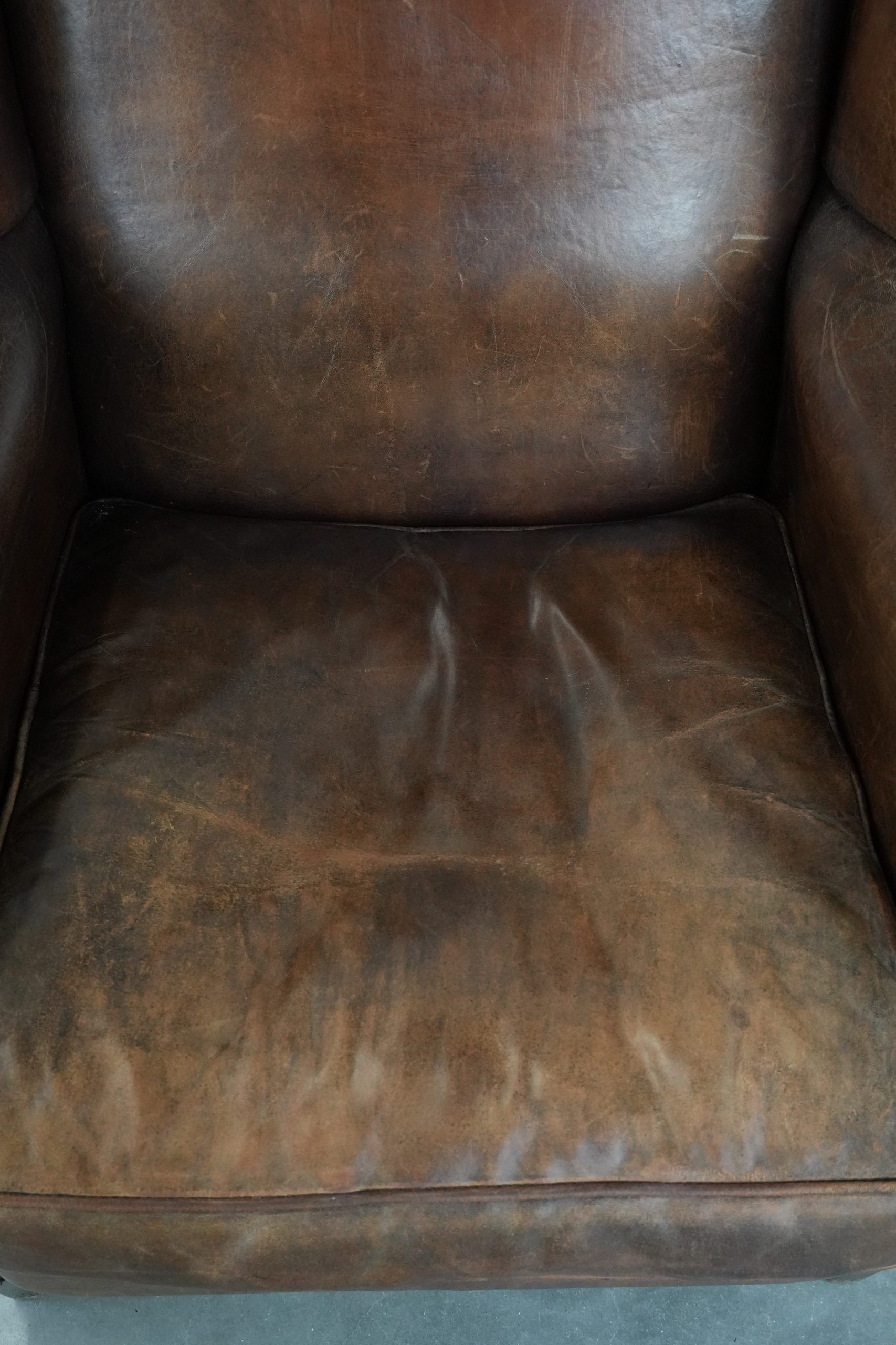 Vintage wingback armchair made of sheepskin leather with beautiful colours