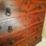 Antique chest of drawers with mahogany veneer and lion heads