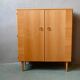 Vintage 1960s shoe cabinet in light wood and chrome metal.