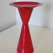 Vintage design candlestick in red metal in the shape of an hourglass