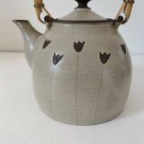 Beige stoneware teapot with stylized flowers and rattan handle