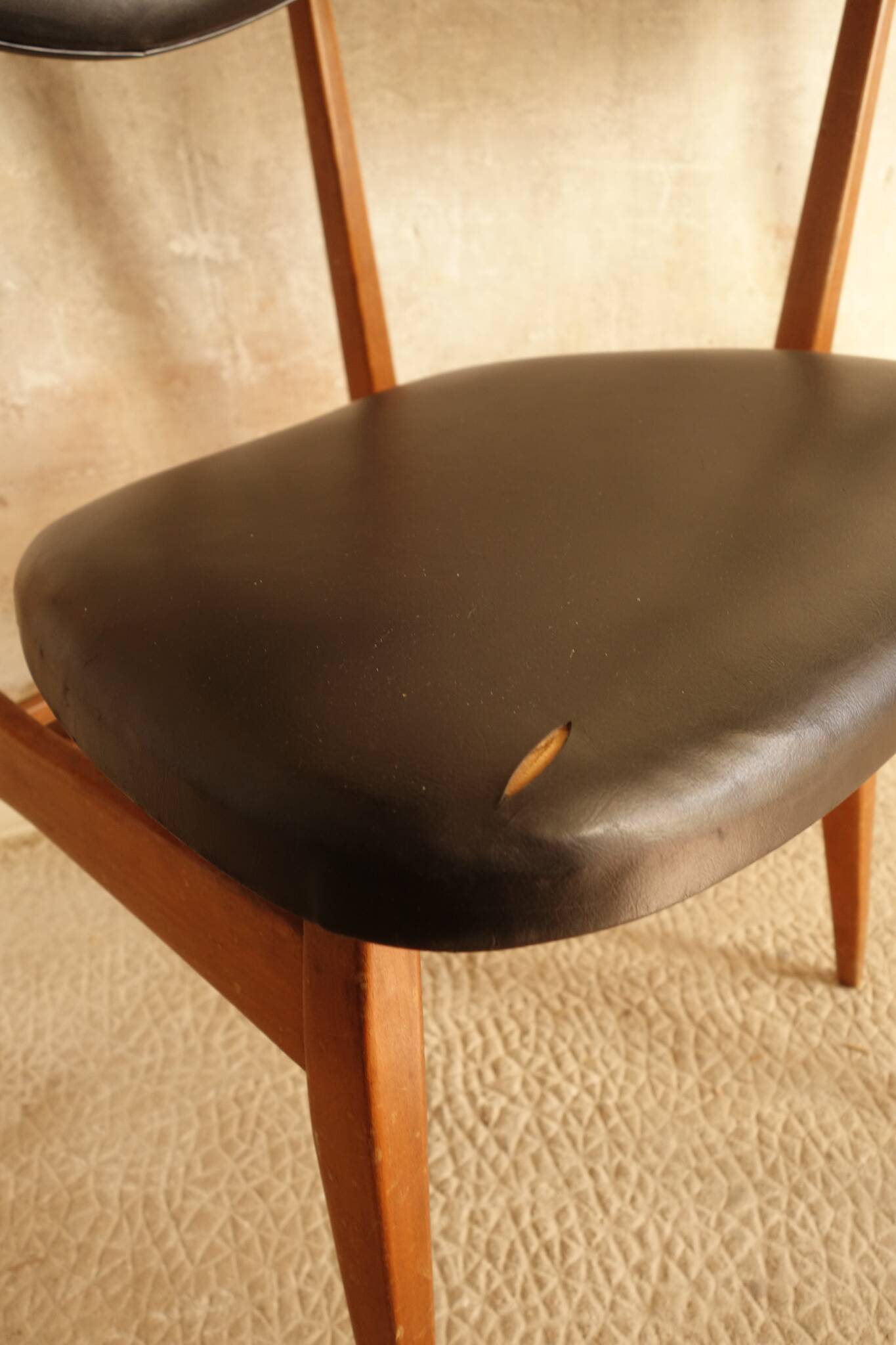 Pair of modernist Scandinavian chairs in teak and black faux leather.