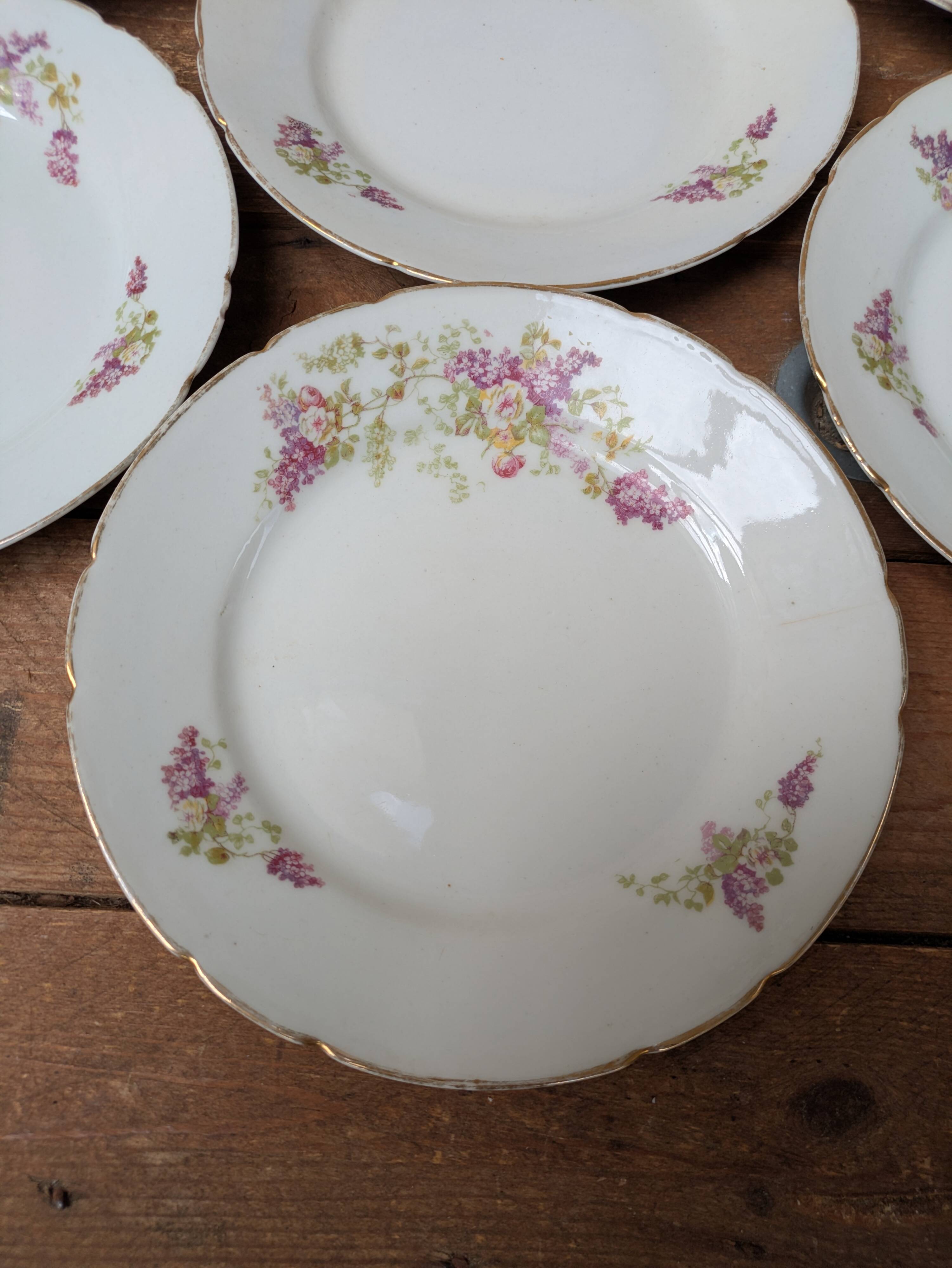 7 dessert plates in porcelain with a violet lilac design and a gold rim.