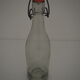 Bottle with mechanical closure in white glass and porcelain stopper.