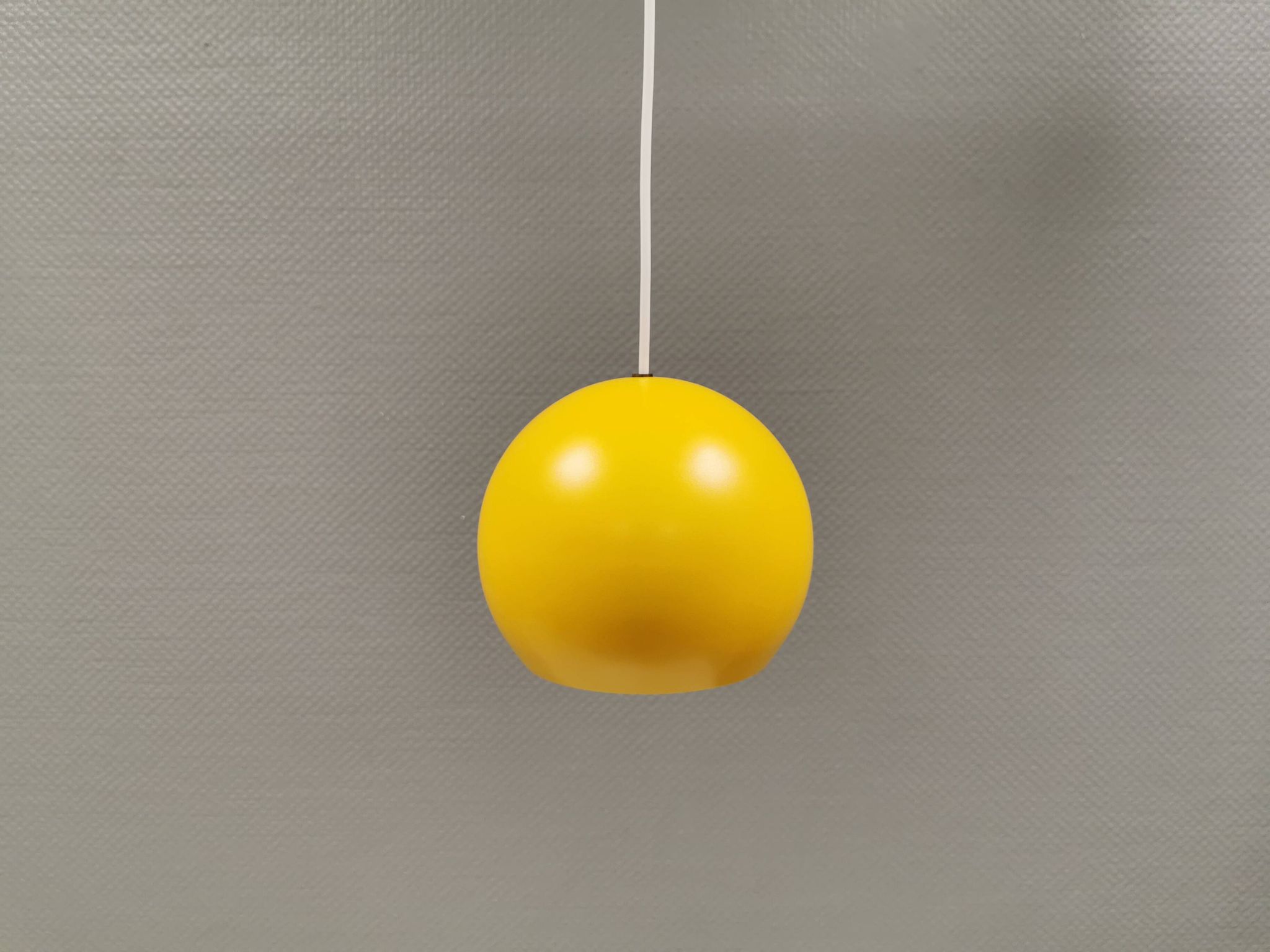 Lampe suspendue sphérique en jaune ensoleillé.