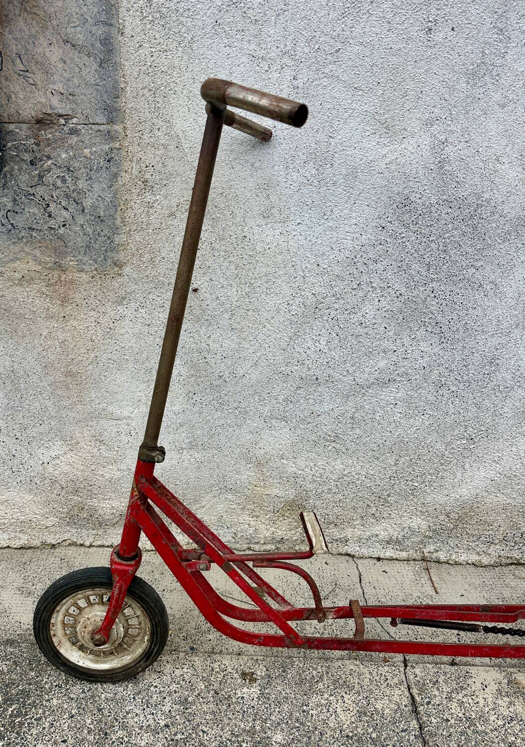 Trottinette rouge ancienne à pédale et chaîne