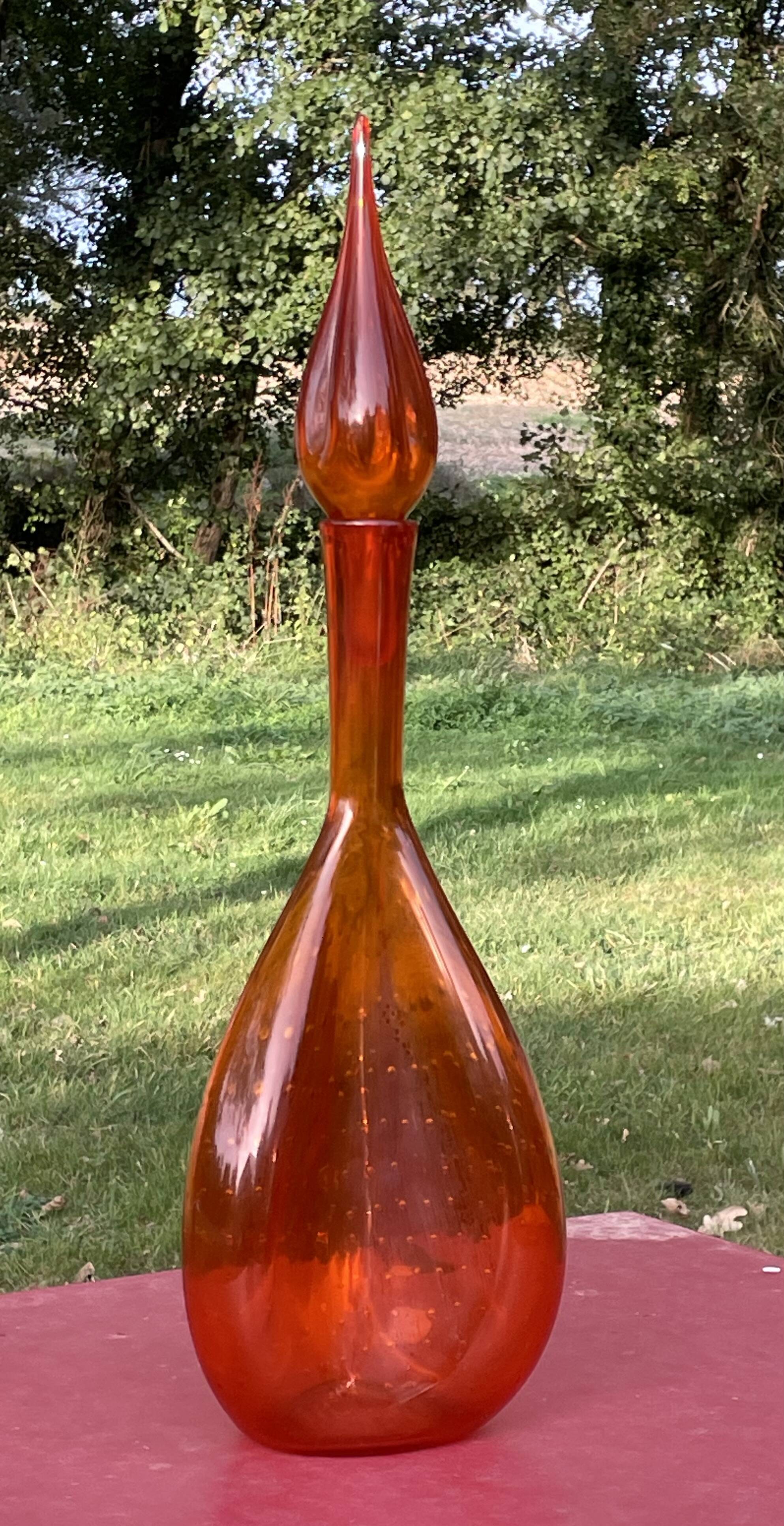 Orange bubbled glass bottle with curved body, circa 1970