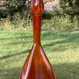 Orange bubbled glass bottle with curved body, circa 1970
