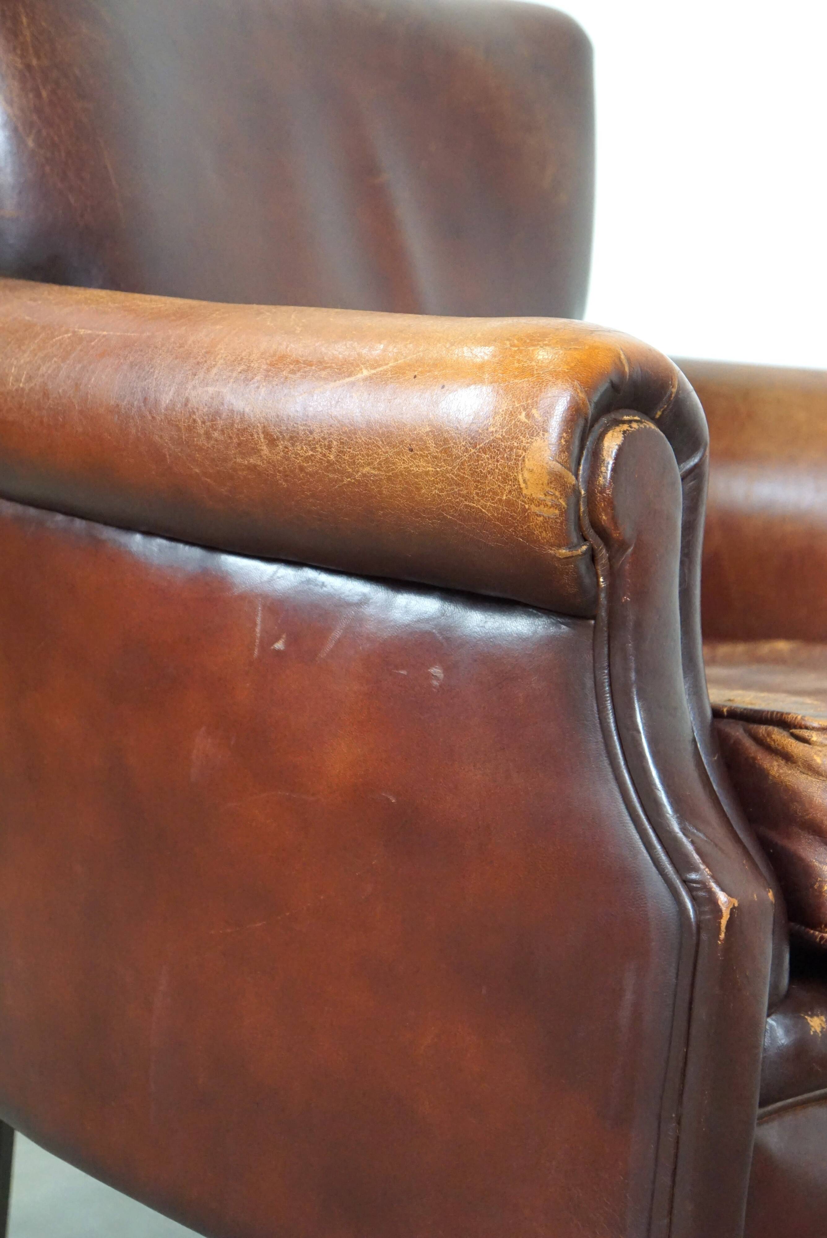 Fauteuil en cuir de mouton robuste et usé mais très confortable avec une belle patine
