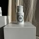 A pair of white glass bottles with Italian green patterns.