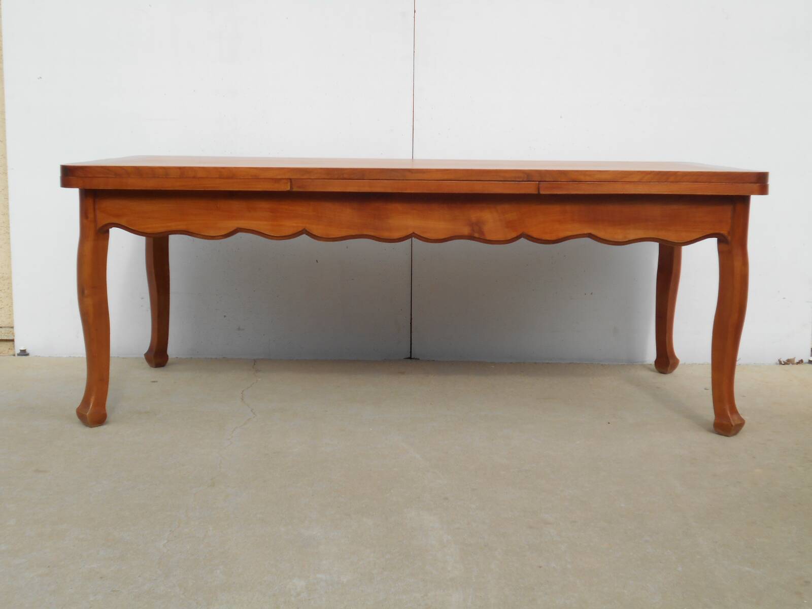 Large solid wood table with integrated extensions.