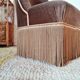 Brown velvet crapaud armchair with fringes and sculpted legs.