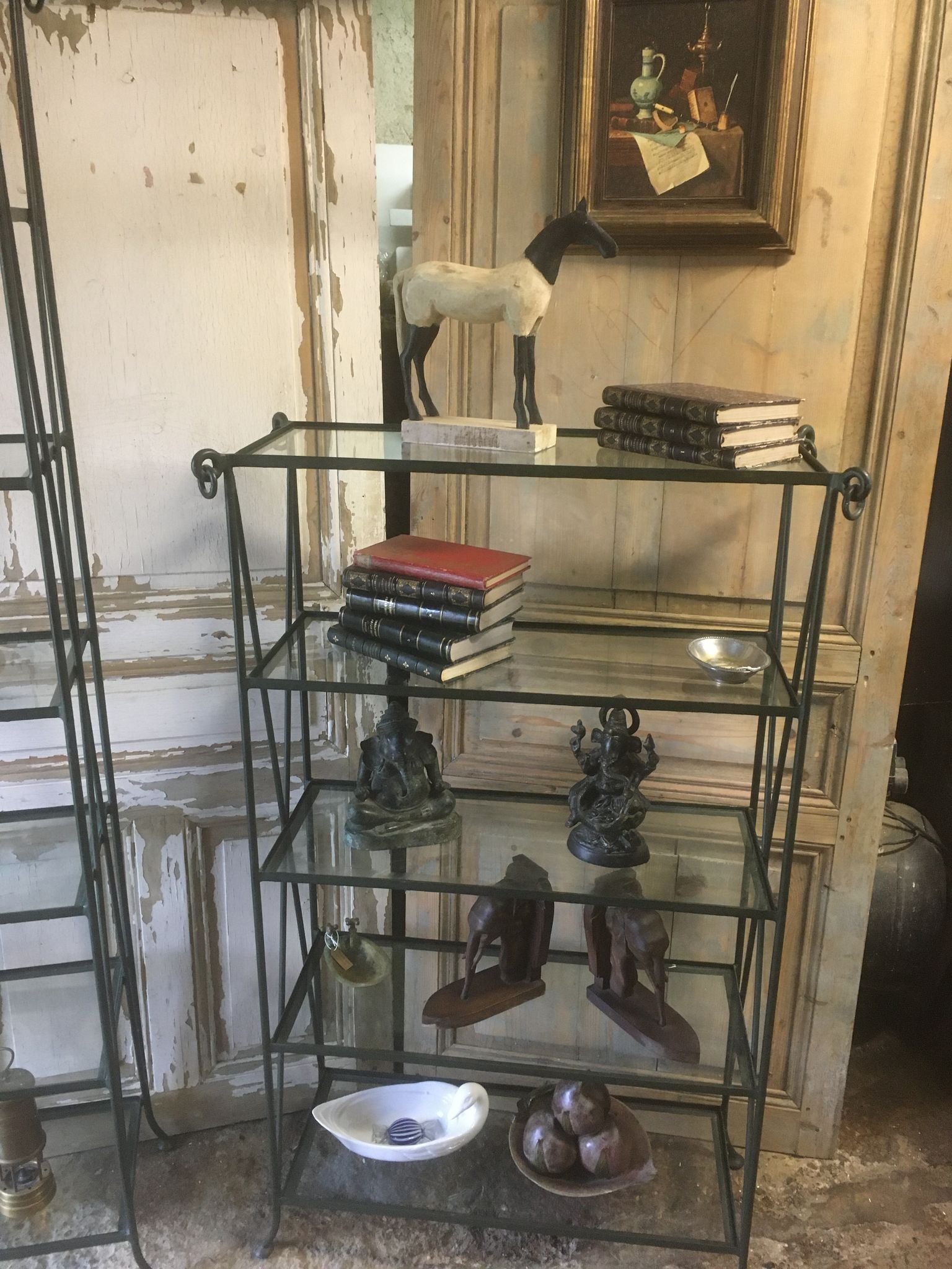 Pair of wrought iron and glass bookshelf shelves.