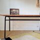 Metal tubular leg table with a wooden top.