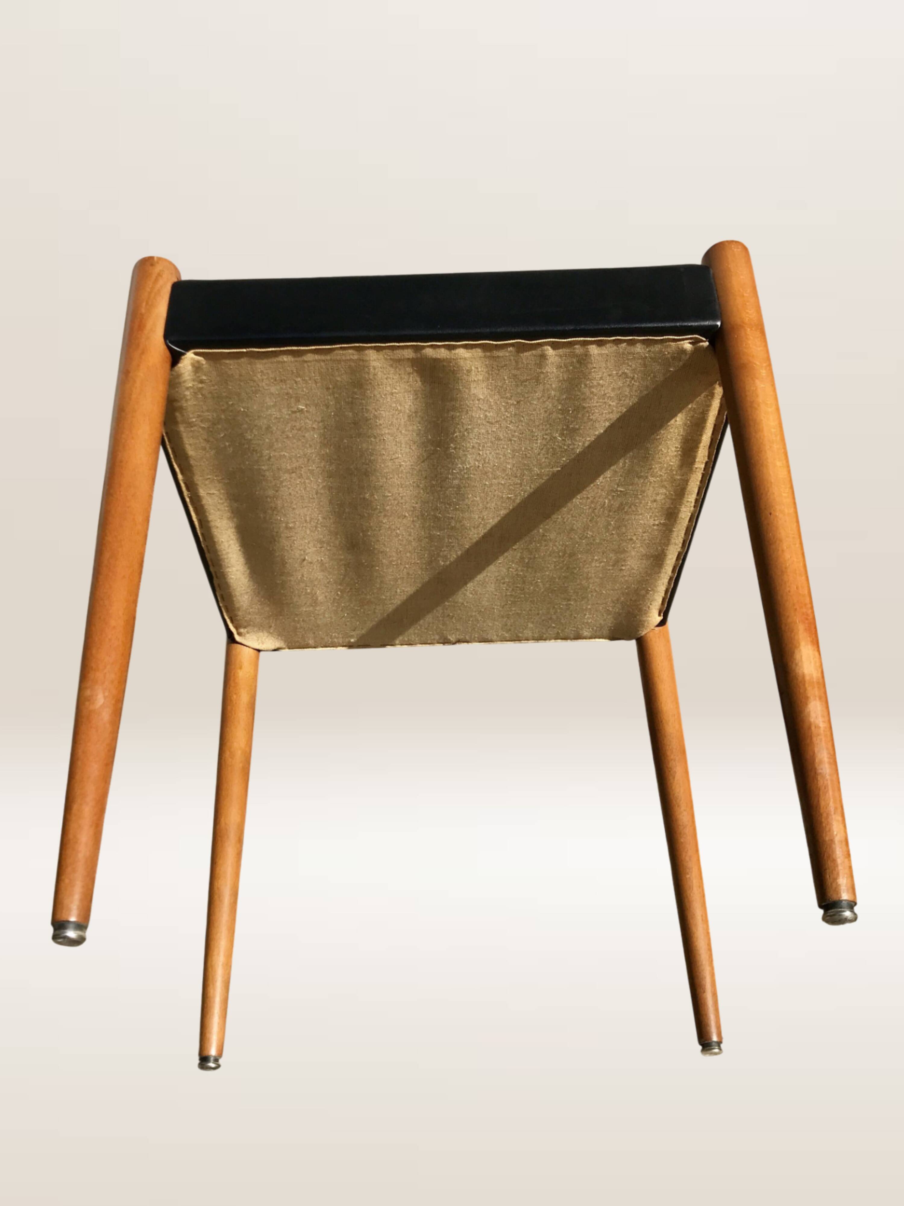Set of 6 modernist chairs with black faux leather seats.