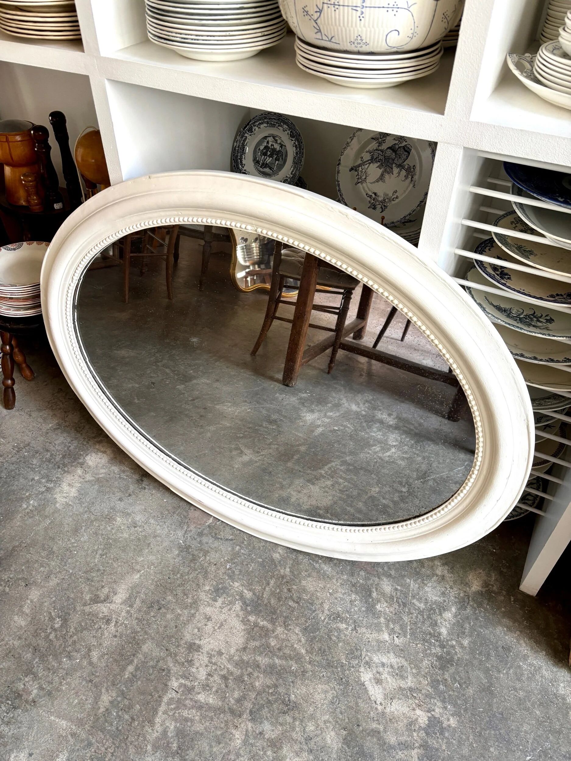 Oval mirror in pearl-coloured stucco 85 x 114 cm