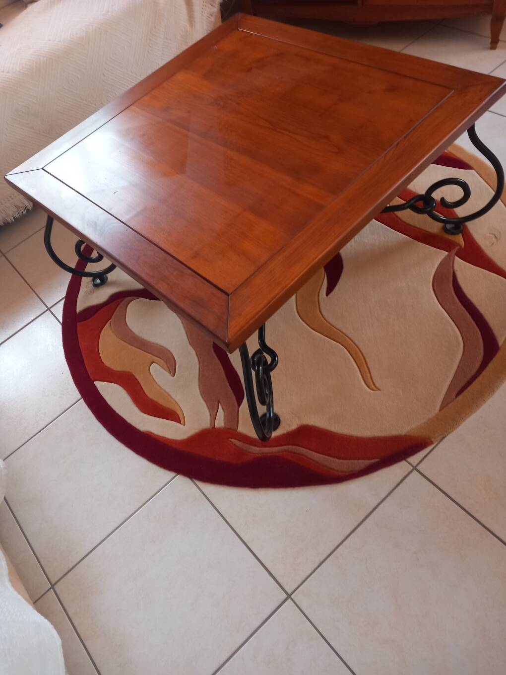 Coffee table in cherry wood with a wrought iron base.