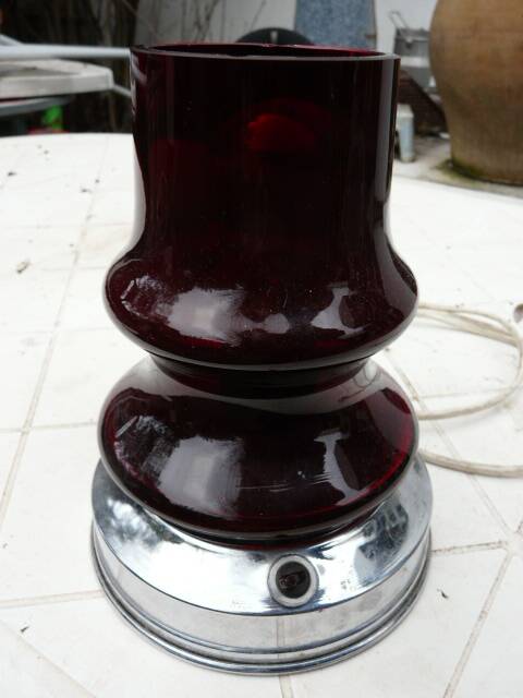 Red glass table lamp on a chrome base.