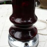Red glass table lamp on a chrome base.