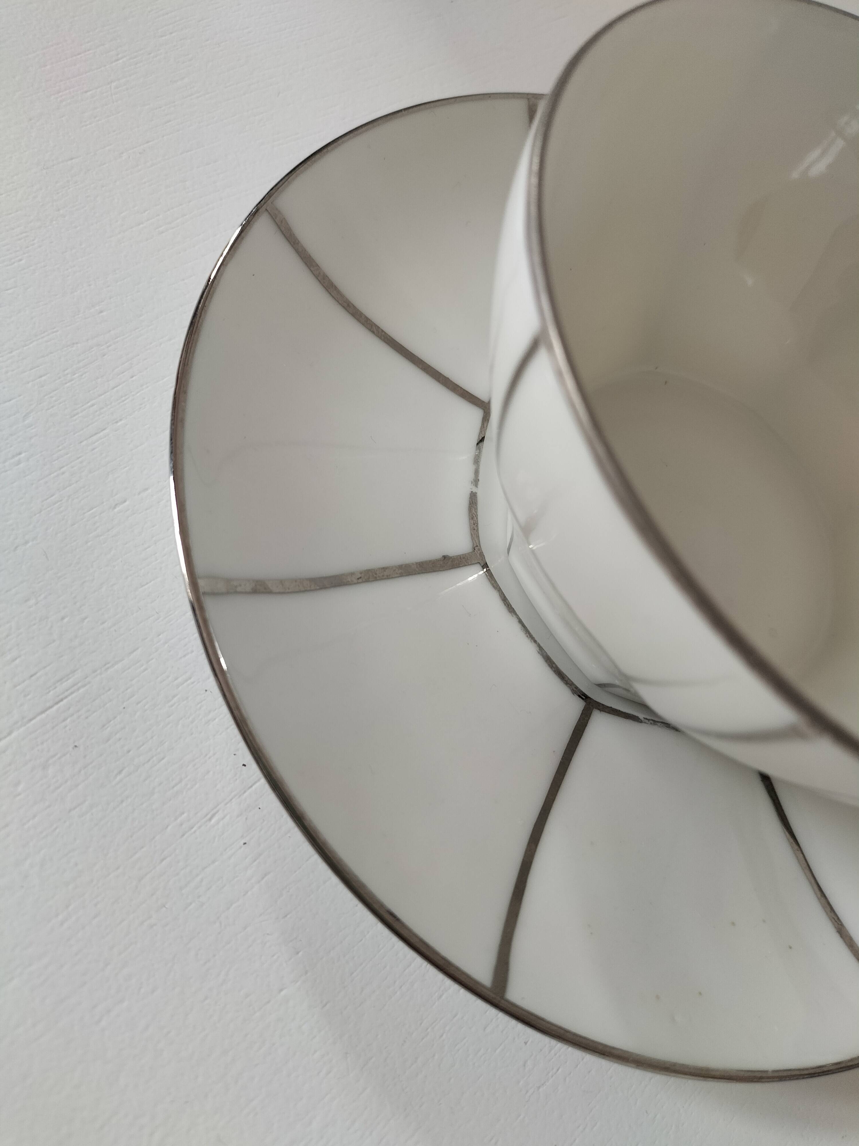 Two Art Deco porcelain cups and saucers with silver trim.