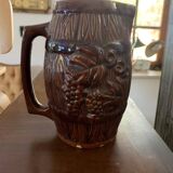 Hungarian folk ceramic pitcher with a brown glossy finish and relief decoration of vine.