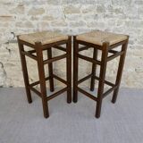pair of bar stools, made of wood with a straw seat