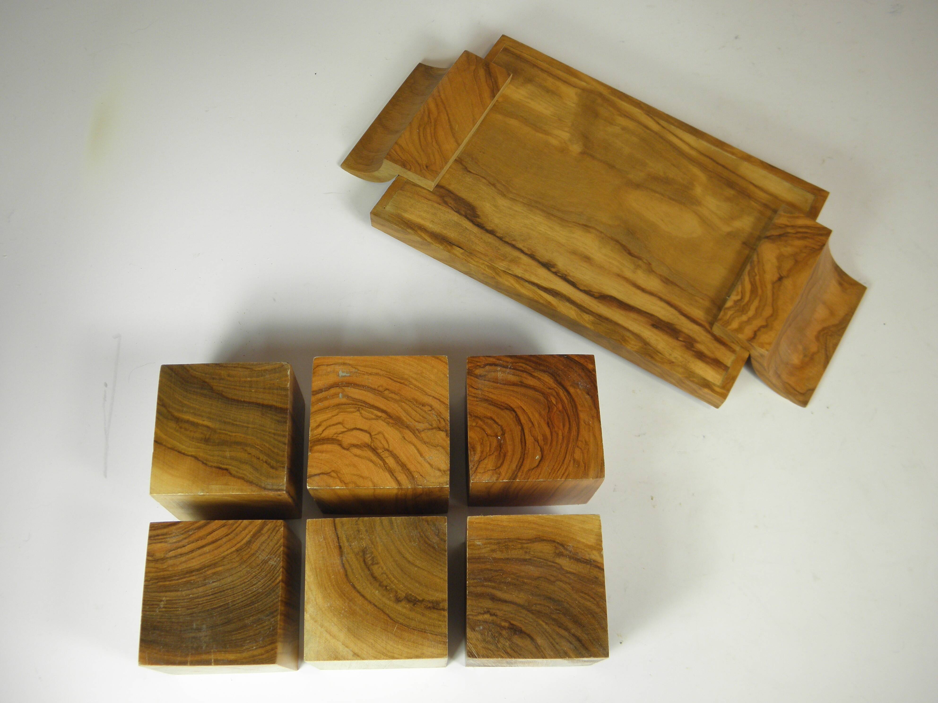 Six egg cups on a wooden tray.