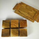 Six egg cups on a wooden tray.