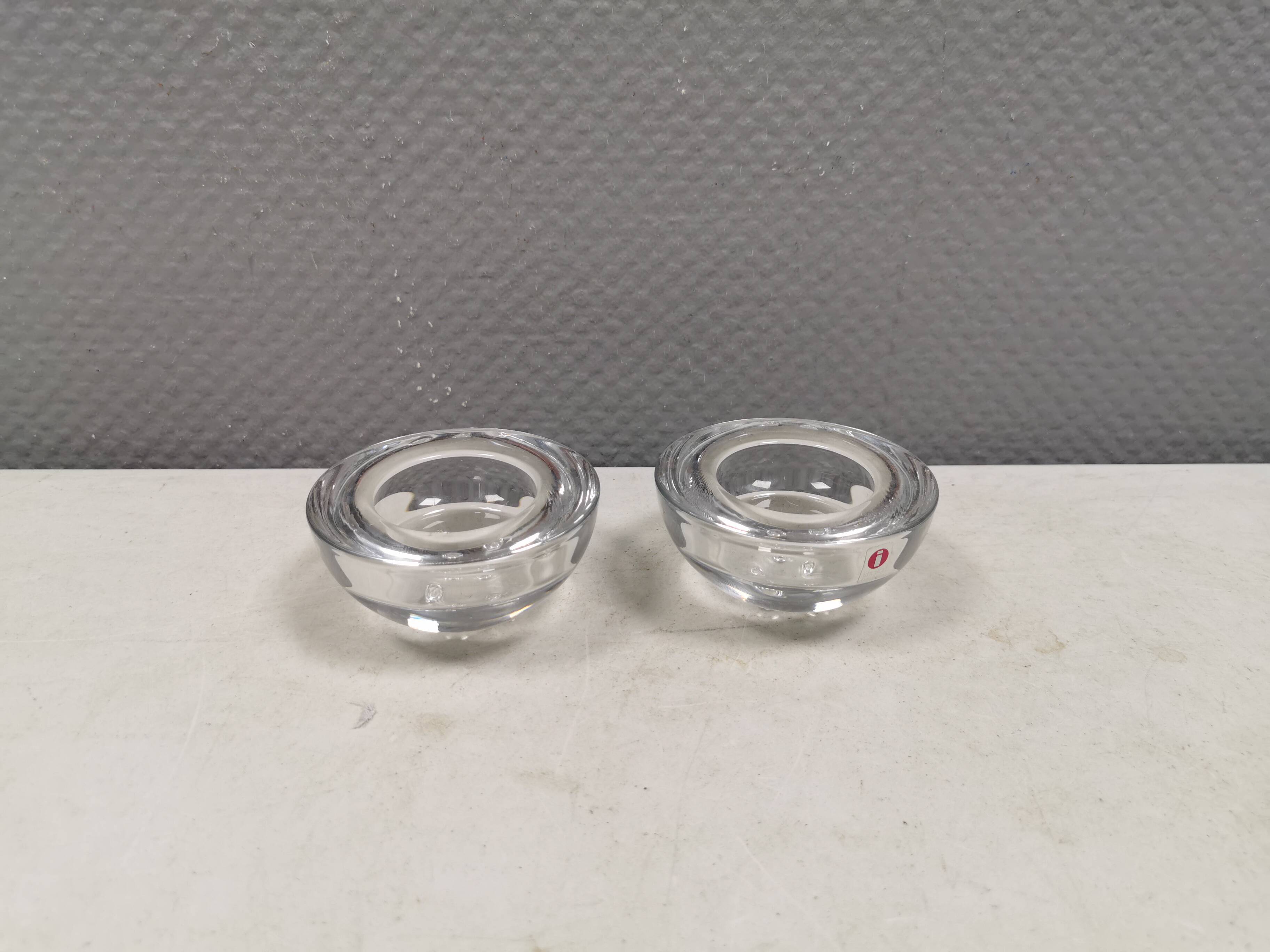 A set of iittala candle holders in clear transparent glass.