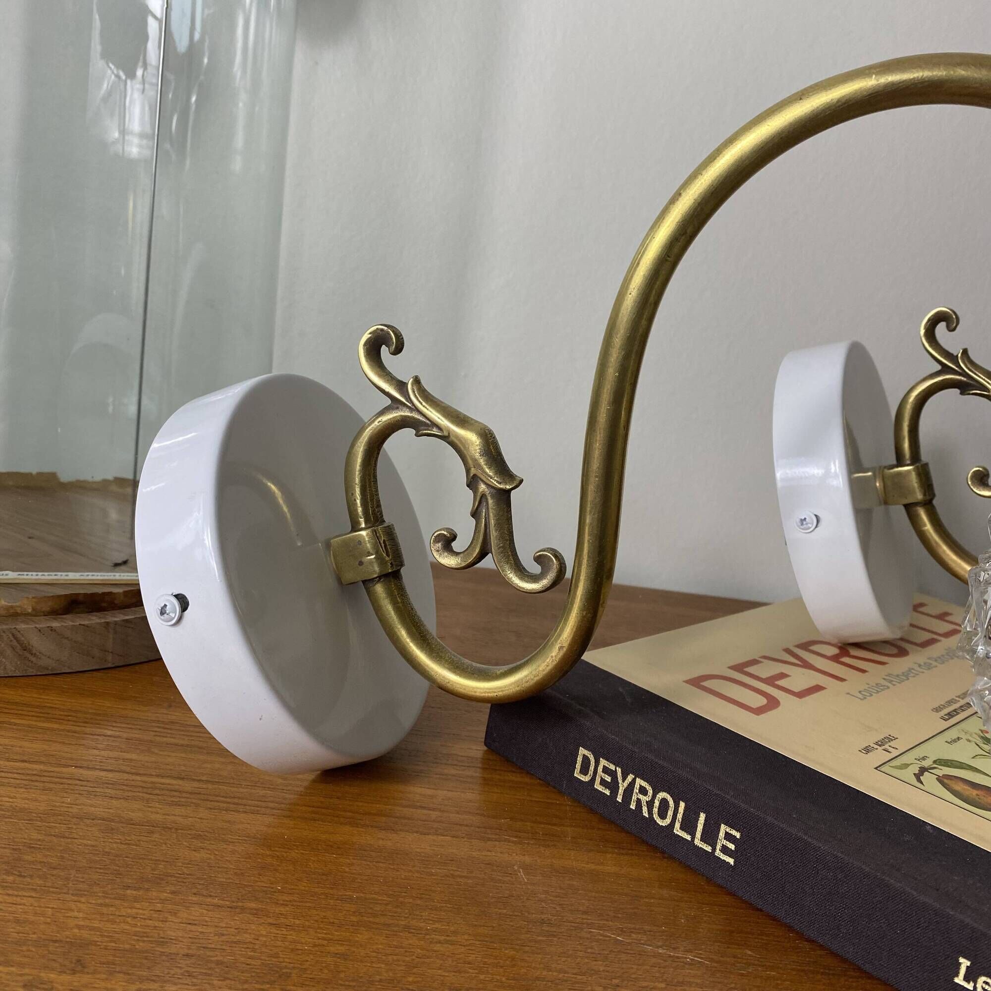 Large pair of brass swan neck wall lights with transparent glass globes.