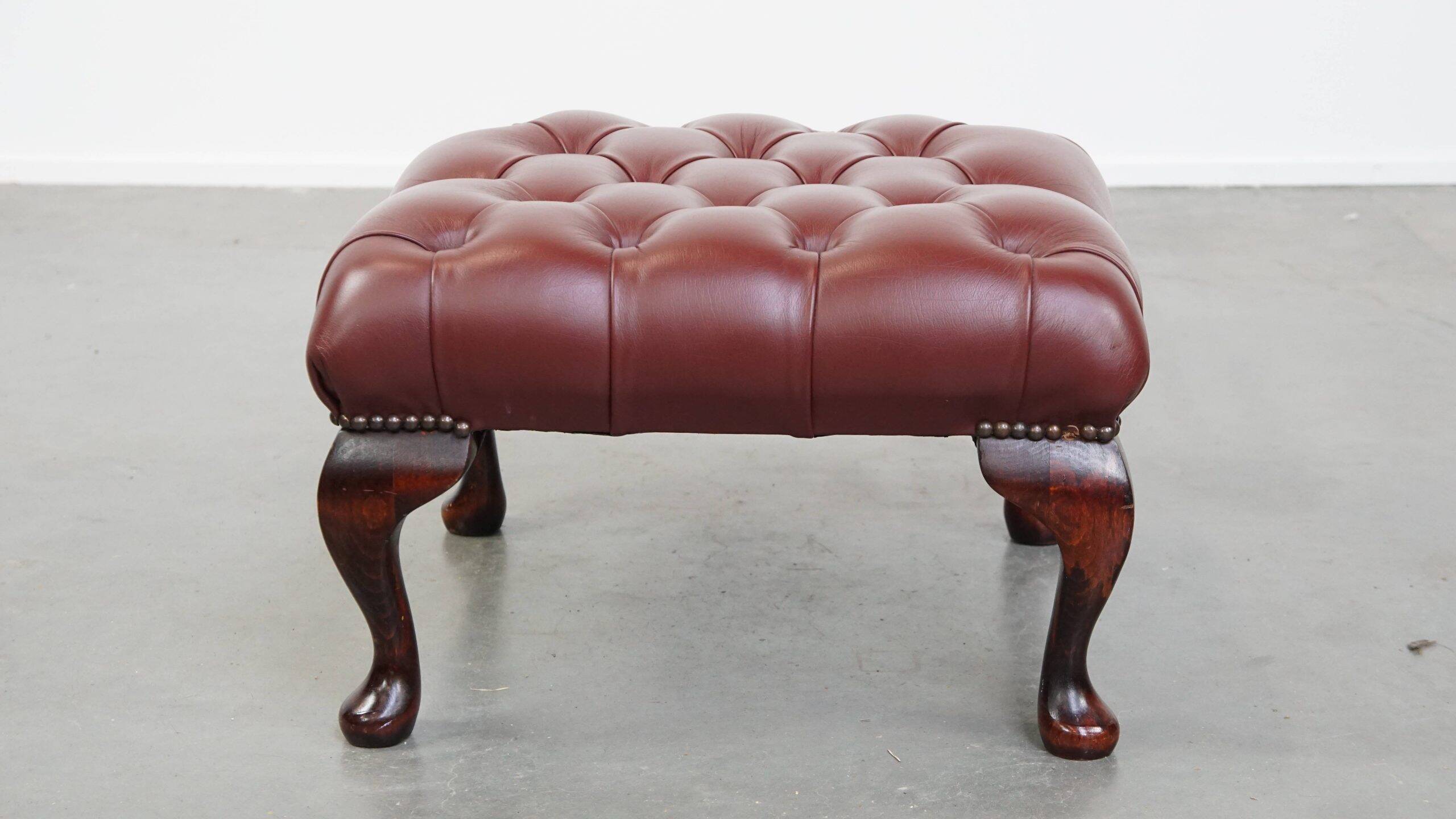 In very good condition elegant red/brown chesterfield ottoman made of cow leather