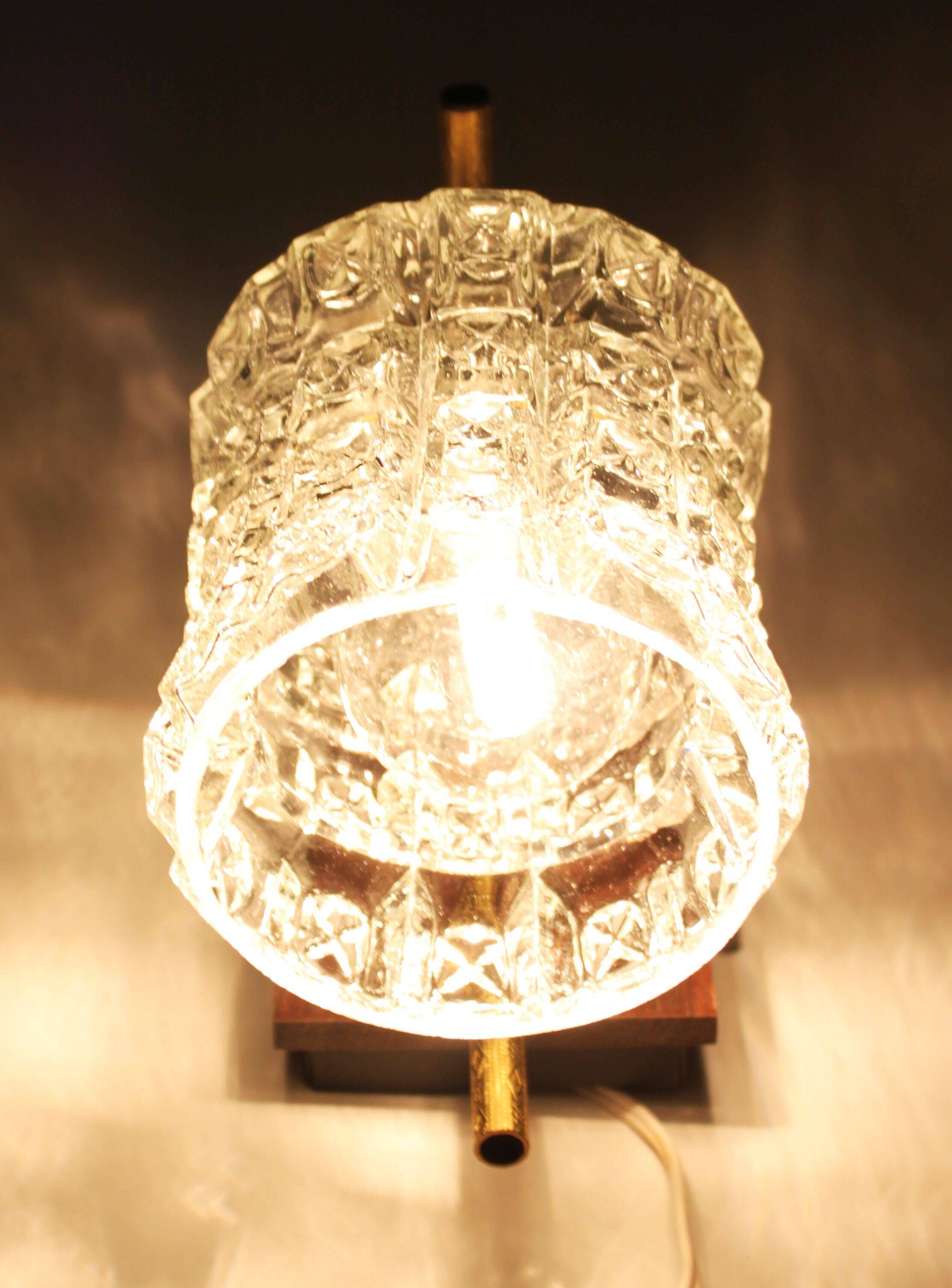 Pair of wall sconces in textured glass, wood, and gold metal, 1970.