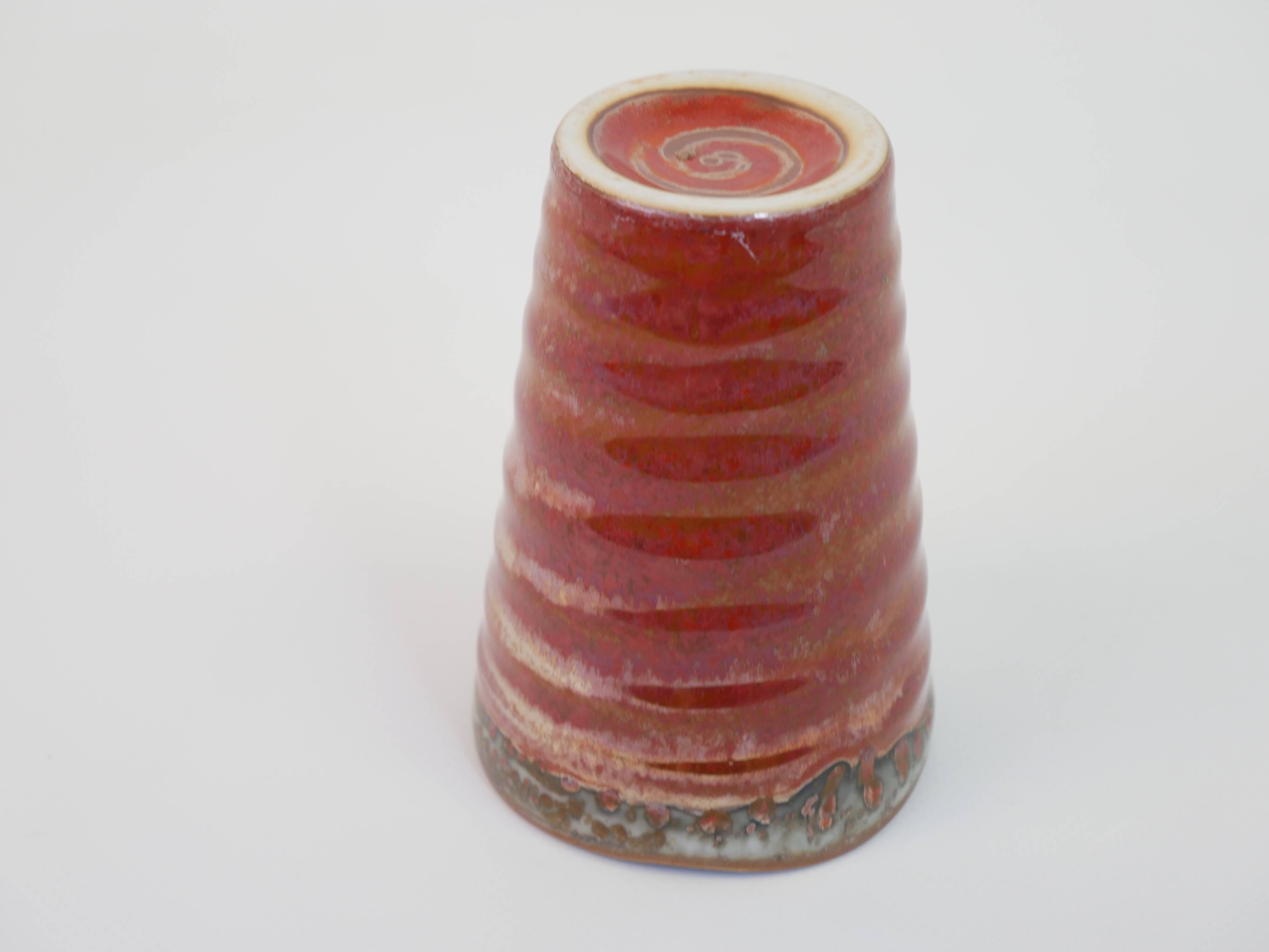Small orange glazed ceramic cup